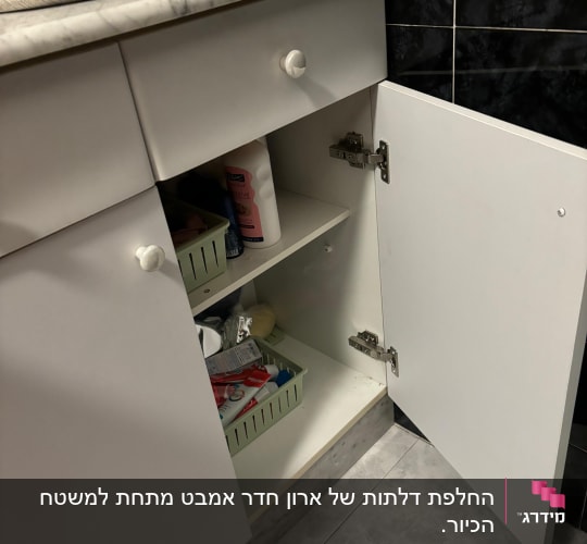 ארון מטבח פתוח עם מוצרי ניקוי וסלסלות אחסון